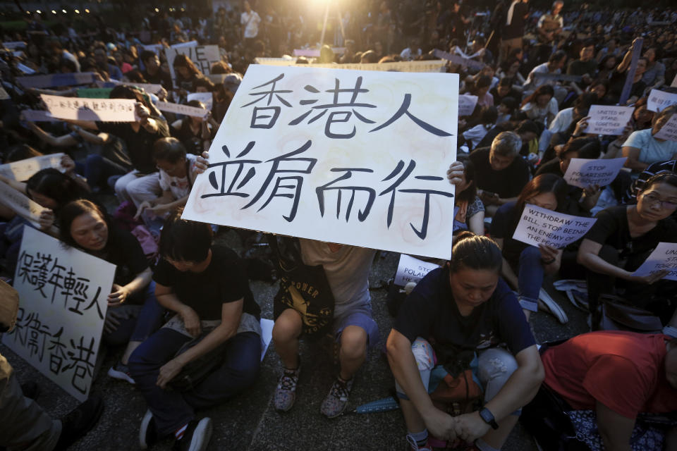 A woman holds up a banner reads "Hong Kong people walk side by side" during a rally by mothers in support of student protesters in Hong Kong on Friday, July 5, 2019. Student unions from two Hong Kong universities said Friday that they have turned down invitations from city leader Carrie Lam for talks about the recent unrest over her proposal to allow the extradition of suspects to mainland China. (AP Photo/Andy Wong)