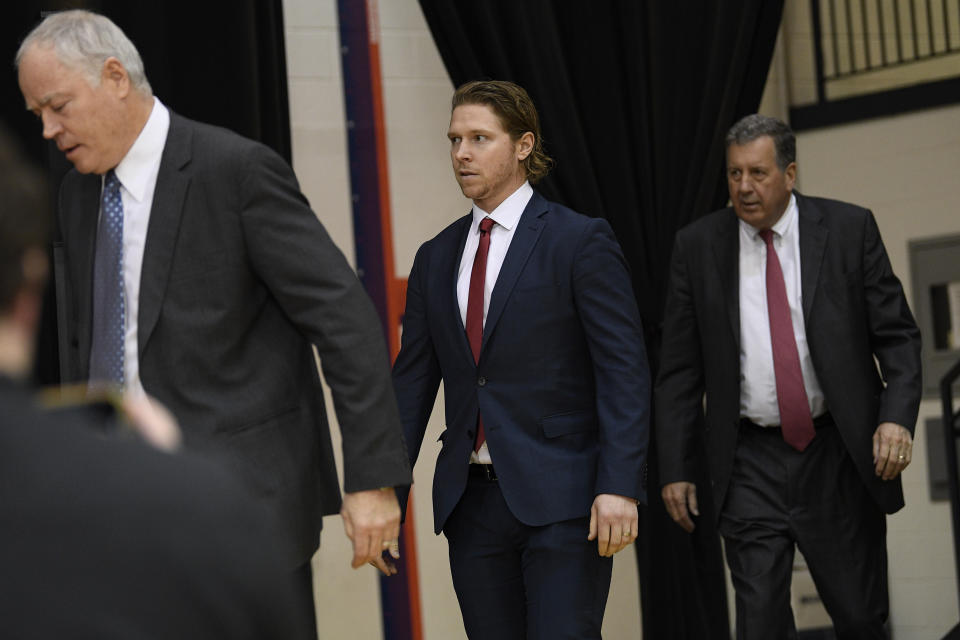 Washington Capitals center Nicklas Backstrom, center, of Sweden, arrives for an NHL hockey news conference about the Capitals re-signing him to a five-year contract, Tuesday, Jan. 14, 2020, in Washington. Also seen are Capitals president Dick Patrick, right, and general manager Brian MacLellan, at left. (AP Photo/Nick Wass)