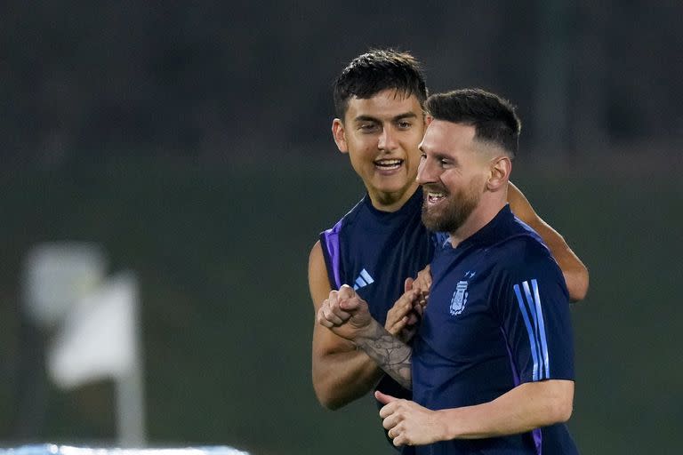 Los delantero argentino Lionel Messi y Paulo Dybala (siempre con una sonrisa) durante un entrenamiento en la víspera de la final del Mundial contra Francia, el sábado 17 de diciembre de 2022, en Doha, Qatar. (AP Foto/Natacha Pisarenko)