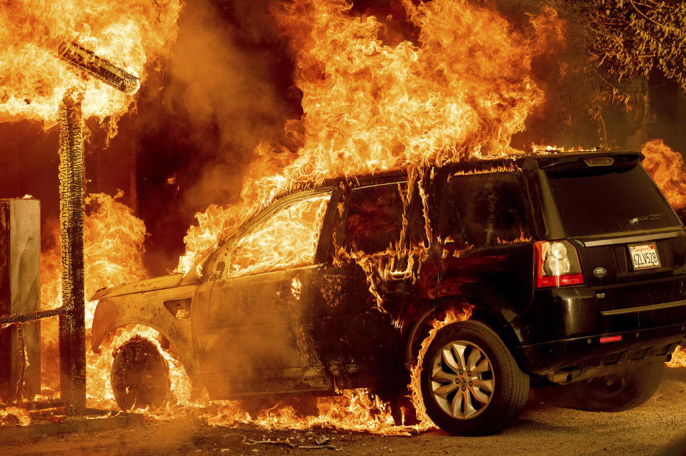 Flames consume a vehicle as the Sugar Fire, part of the Beckwourth Complex Fire, tears through Doyle, Calif., Saturday, July 10, 2021. Pushed by heavy winds amid a heat wave, the fire came out of the hills and destroyed multiple residences in central Doyle. (AP Photo/Noah Berger)