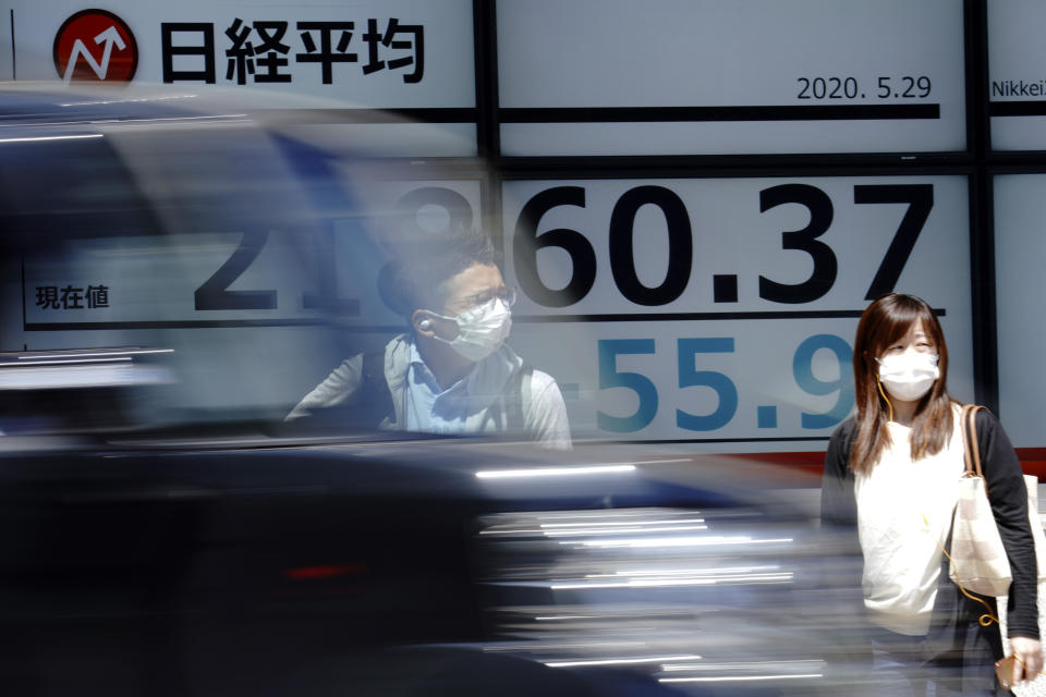 A man and a woman stand in front of an electronic stock board showing Japan's Nikkei 225 index at a securities firm as a car drives by in Tokyo Friday, May 29, 2020. Shares fell Friday in Asia after Wall Street’s rally petered out amid worries about flaring U.S.-China tensions.(AP Photo/Eugene Hoshiko)