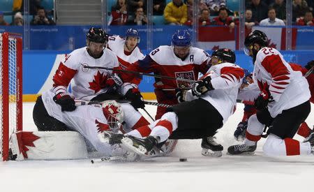 Ice Hockey - Pyeongchang 2018 Winter Olympics - Men's Bronze Medal Match - Czech Republic v Canada - Gangneung Hockey Centre, Gangneung, South Korea - February 24, 2018 - Goalie Kevin Poulin of Canada stretches for the puck amid goal mouth action. REUTERS/Kim Kyung-Hoon