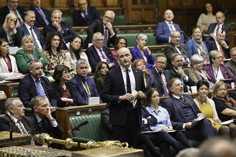 Stephen Flynn standing in parliament in front of benches of Scottish National Party MPs.