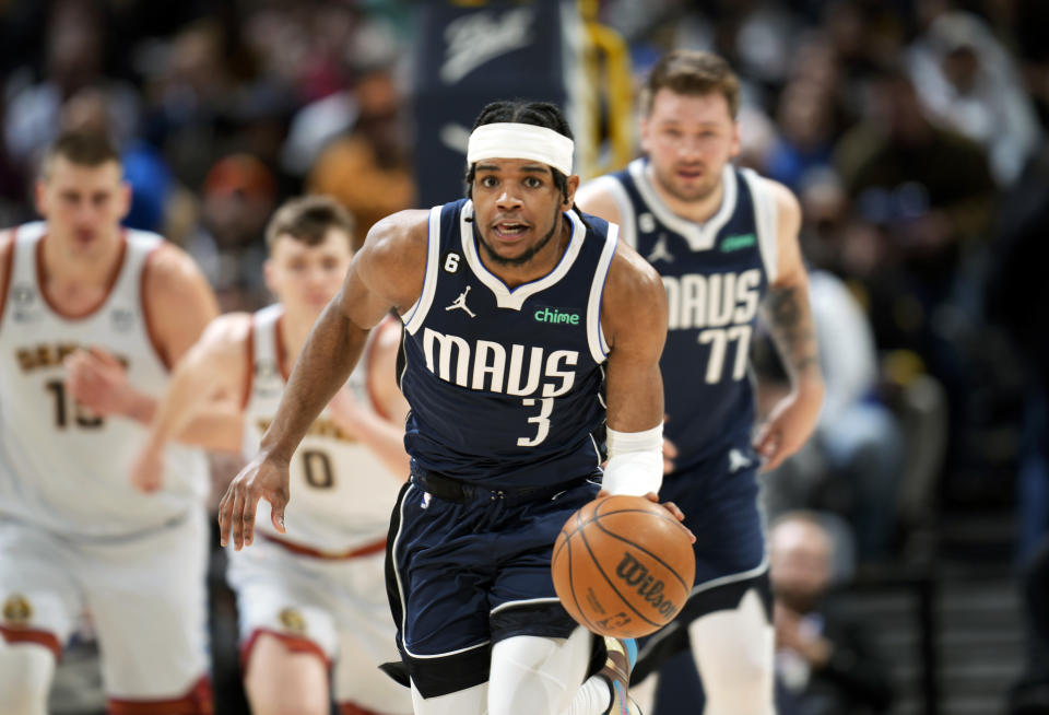 Dallas Mavericks guard Jaden Hardy picks up a loose ball in the first half of an NBA basketball game against the Denver Nuggets Wednesday, Feb. 15, 2023, in Denver. (AP Photo/David Zalubowski)