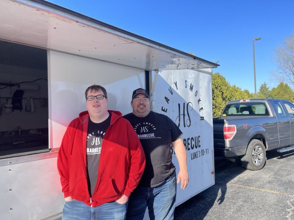 Brothers Phil Ludens (left) and Kevin Ludens (right) stand in front of Kevin's new food truck business, Heavy Smoker BBQ.