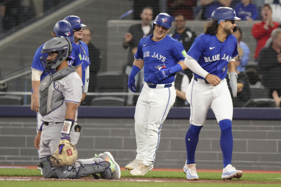 Toronto Blue Jays' Daulton Varsho, center, celebrates at the plate after hitting a grand slam off Colorado Rockies pitcher Dakota Hudson during the first inning of a baseball game in Toronto, Saturday, April 13, 2024. (Chris Young/The Canadian Press via AP)
