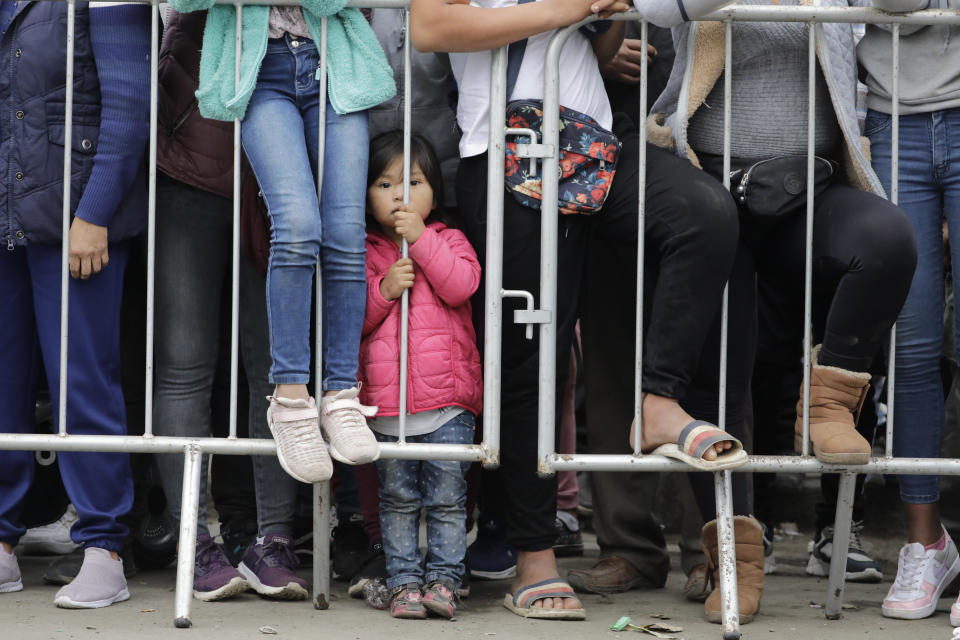 A child stands behind a barricade as supporters of Presidential candidate Keiko Fujimori watch her arrive to cast her vote in Lima, Peru, Sunday, June 6, 2021. Peruvians head to the polls in a presidential run-off election to choose between Fujimori, the daughter of jailed ex-President Alberto Fujimori, and political novice Pedro Castillo. (AP Photo/Guadalupe Pardo)