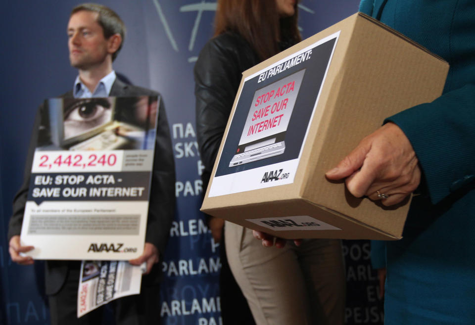 Avaaz's campaign director Alex Wilks, background, reacts to the media, prior to handing over of a petition against the Anti-Counterfeiting Trade Agreement (ACTA), to members of the European Parliament, at the European Parliament in Brussels, Tuesday, Feb. 28, 2012. Avaaz, an organization that uses the Internet to mobilize support for various political issues. (AP Photo/Yves Logghe)