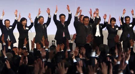 Japan's Prime Minister Shinzo Abe (4th L) shouts "Banzai!" (Cheers) as he and other members of the ruling Liberal Democratic Party (LDP) throw their hands in the air during the annual party convention in Tokyo, in this file picture taken January 19, 2014. REUTERS/Yuya Shino/Files