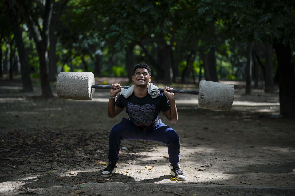 Daniel Fonseca, de 15 años, levanta bloques de concreto en un gimnasio público en el parque de Los Caobos en Caracas, Venezuela, el martes 23 de julio de 2024. Venezuela celebrará sus elecciones presidenciales el 28 de julio. (AP Foto/Fernando Vergara)