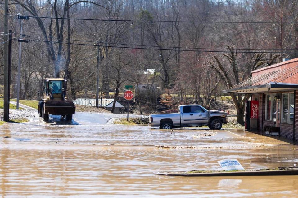 A utility vehicle works to remove water and mud from Lumber Street after severe flooding in downtown in Beattyville Ky., Wednesday, March 3, 2021.