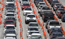 Lines of cars wait at a coronavirus testing site outside of Hard Rock Stadium, Friday, June 26, 2020, in Miami Gardens, Fla. Florida banned alcohol consumption at its bars Friday as its daily confirmed coronavirus cases neared 9,000, a new record that is almost double the previous mark set just two days ago. (AP Photo/Wilfredo Lee)