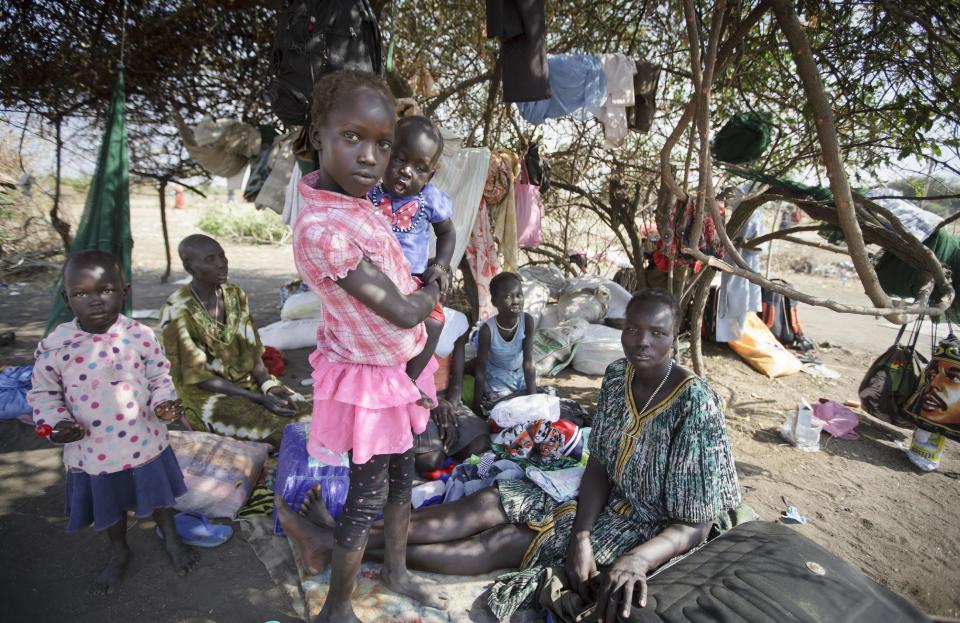 A displaced family camp under a tree providing partial shade from the midday sun, some of the thousands who fled the recent fighting between government and rebel forces in Bor by boat across the White Nile, in the town of Awerial, South Sudan Thursday, Jan. 2, 2014. The international Red Cross said Wednesday that the road from Bor to the nearby Awerial area "is lined with thousands of people" waiting for boats so they could cross the Nile River and that the gathering of displaced is "is the largest single identified concentration of displaced people in the country so far". (AP Photo/Ben Curtis)