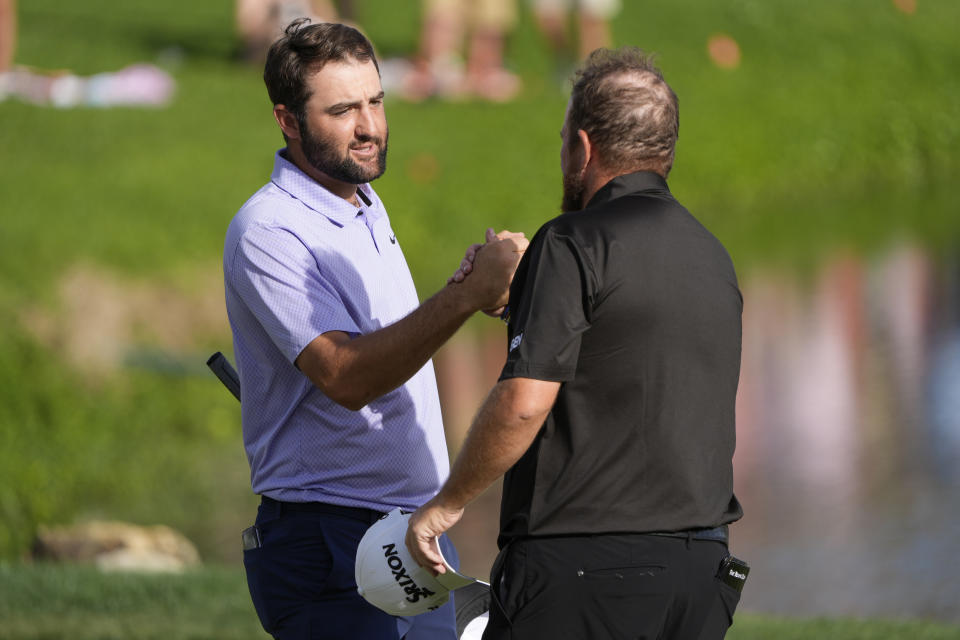 Scottie Scheffler, left, shakes hands with Shane Lowry, of Ireland, after they finished the final round of the Arnold Palmer Invitational golf tournament Sunday, March 10, 2024, in Orlando, Fla. Scheffler won the tournament and Lowry finished third. (AP Photo/John Raoux)