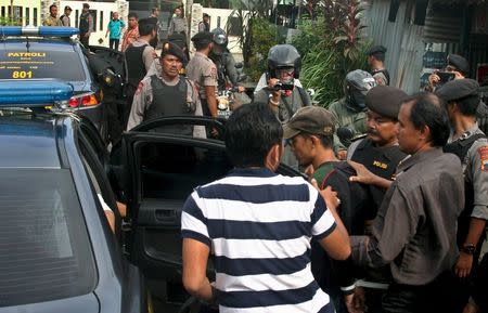 Police officers escorts a man (C, with a cap) who was arrested during a raid in the Langgen village in Tegal, Indonesia Central Java, January 15, 2016 in this photo taken by Antara Foto. REUTERS/Oky Lukmansyah/Antara Foto