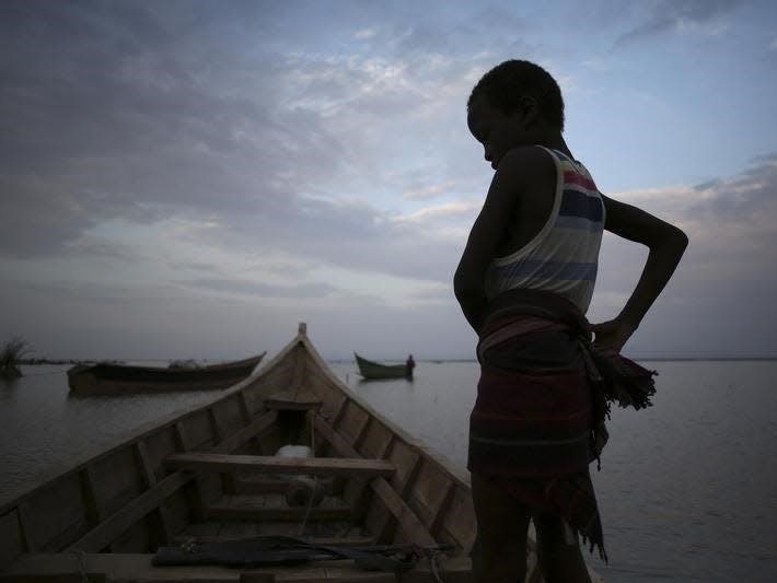 A Dassanach boy stands on a boat by the shore of a fishing camp near the Omo Delta in the north of Lake Turkana close to the town of Ileret and near the Kenyan-Ethiopian border in northern Kenya September 19, 2014. The Dassanach, an ethnic group living mainly in southern Ethiopia, have historically clashed over ethnic differences and precious resources such as fishing, pasture and fresh water with the Turkana of Kenya. REUTERS/Goran Tomasevic