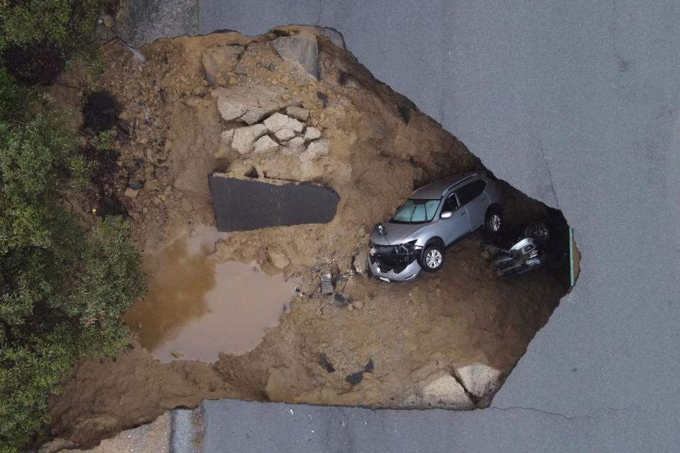 Two cars, with two people in each, were swallowed by a sinkhole in Chatsworth, Los Angeles on Monday evening, prompting a dramatic rescue by firefighters (REUTERS)