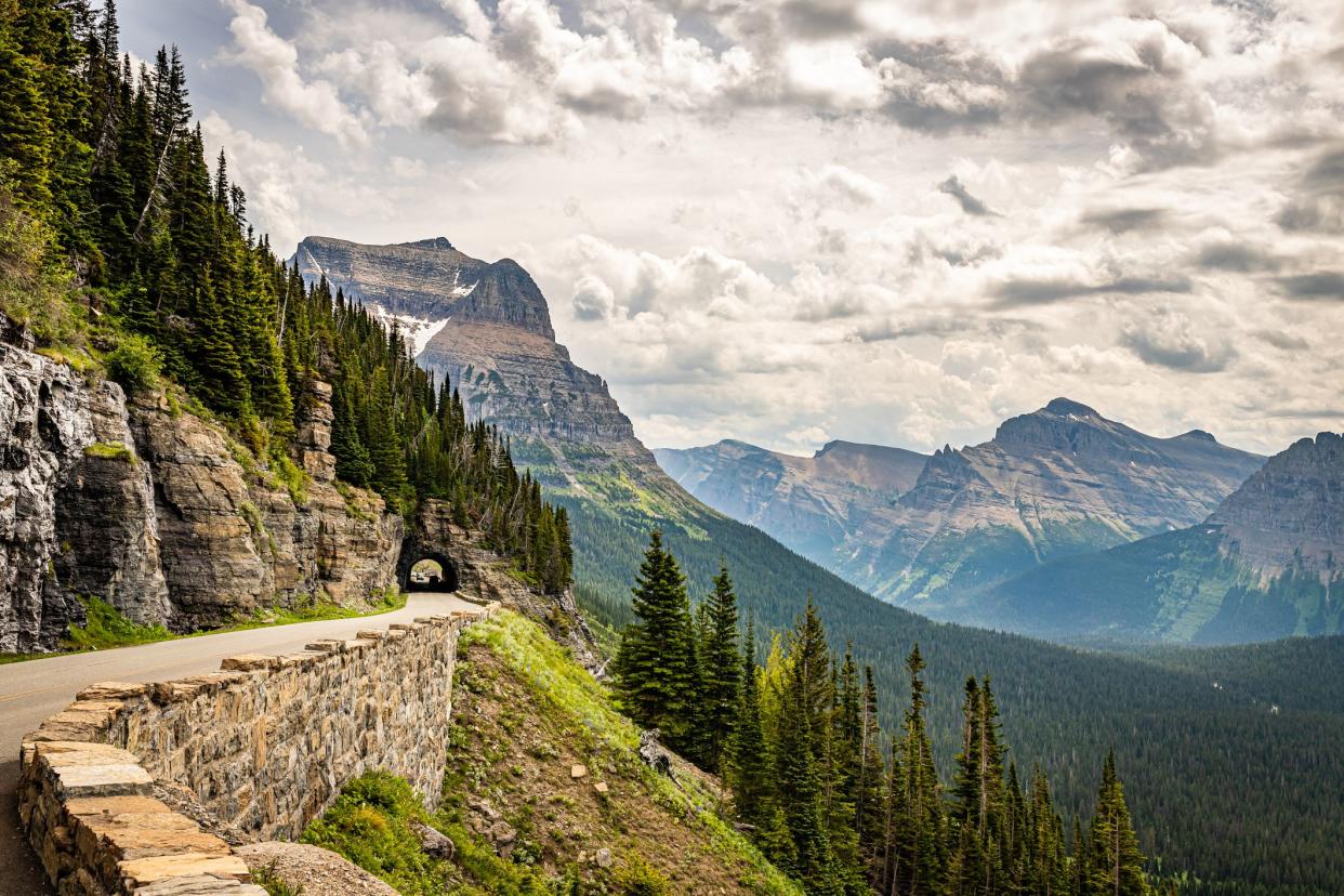 Going-to-the-Sun Road in Glacier National Park, Montana, along mountains with tunnel and mountains with dramatic cloudscape in the background