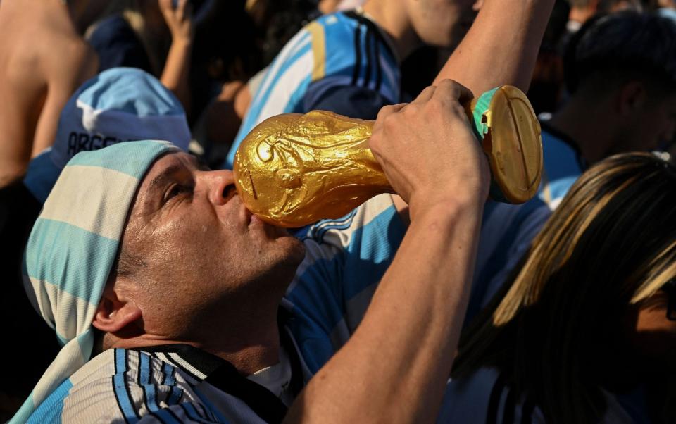 An Argentina fan in Buenos Aires kisses a World Cup replica as he celebrates victory over Croatia - AFP