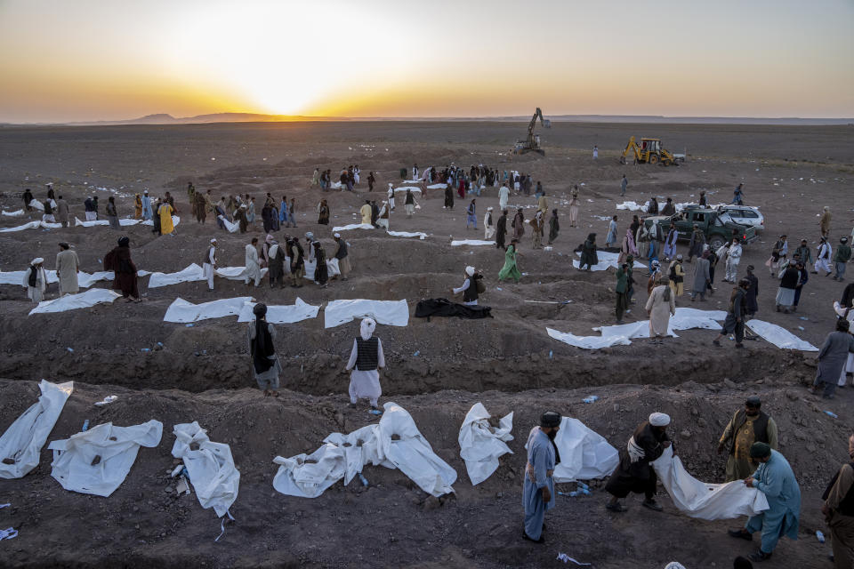 Afghans bury hundreds of people killed in an earthquake to a burial site, outside a village in Zenda Jan district in Herat province, western of Afghanistan, Monday, Oct. 9, 2023. Saturday's deadly earthquake killed and injured thousands when it leveled an untold number of homes in Herat province. (AP Photo/Ebrahim Noroozi)