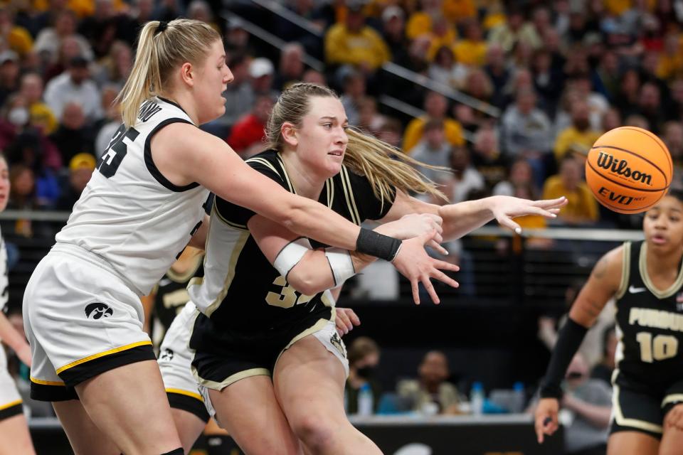 Purdue forward Caitlyn Harper passes the ball away from Iowa forward Monika Czinano (25) during the first half of an NCAA college basketball game at the Big Ten women's tournament Friday, March 3, 2023, in Minneapolis.