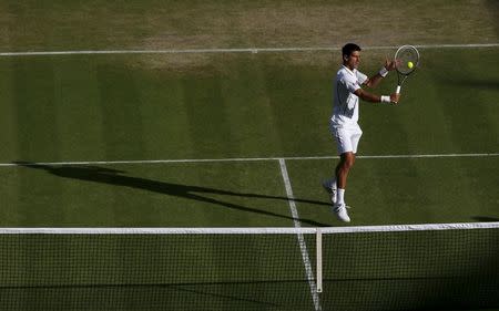 Novak Djokovic of Serbia hits a volley to Jeremy Chardy of France in their men's singles tennis match at the Wimbledon Tennis Championships, in London in this June 29, 2013 file photo. REUTERS/Eddie Keogh/Files