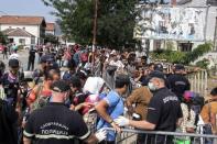 Migrants and refugees wait in line to enter a camp in the town of Presevo, Serbia, August 26, 2015. REUTERS/Agron Beqiri