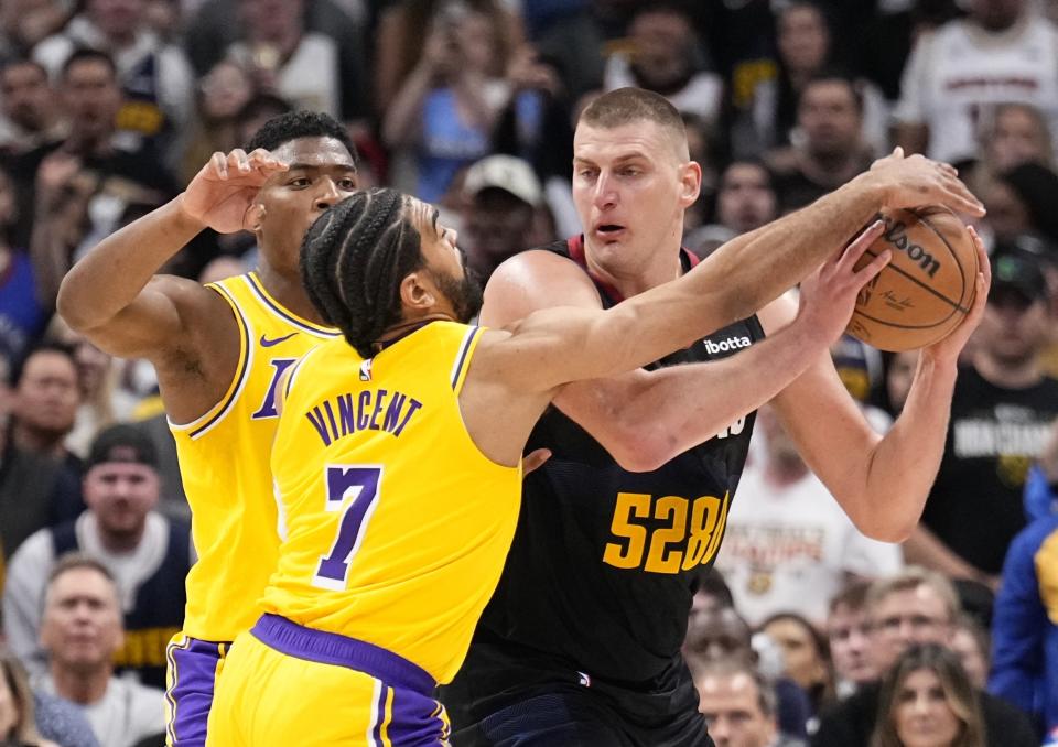 Los Angeles Lakers guard Gabe Vincent (7) pressures Denver Nuggets center Nikola Jokic, right, during the second half in Game 2 of an NBA basketball first-round playoff series Monday, April 22, 2024, in Denver. (AP Photo/Jack Dempsey)