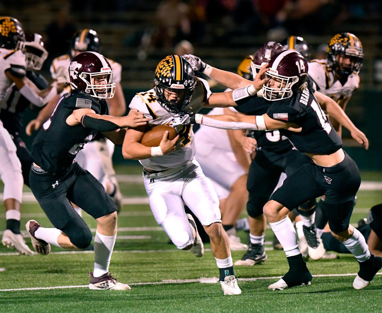 Cisco quarterback Hunter Long is pulled at by Hawley linebacker Will Scott (left) and safety Kason O'Shields during last season's Region I-2A Division I championship game. Hawley won 17-14.