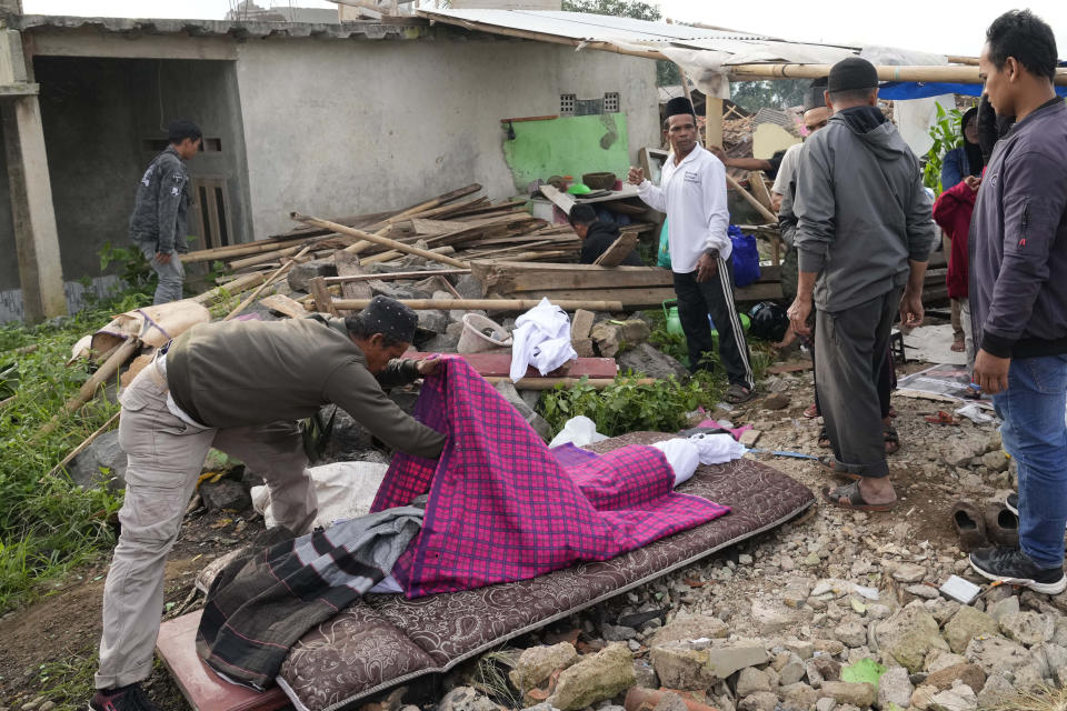 Family members prepare the body of a young earthquake victim for burial in Cianjur, West Java, Indonesia,T uesday, Nov. 22, 2022. Rescuers on Tuesday struggled to find more bodies from the rubble of homes and buildings toppled by an earthquake that killed a number of people and injured hundreds on Indonesia's main island of Java. (AP Photo/Tatan Syuflana)