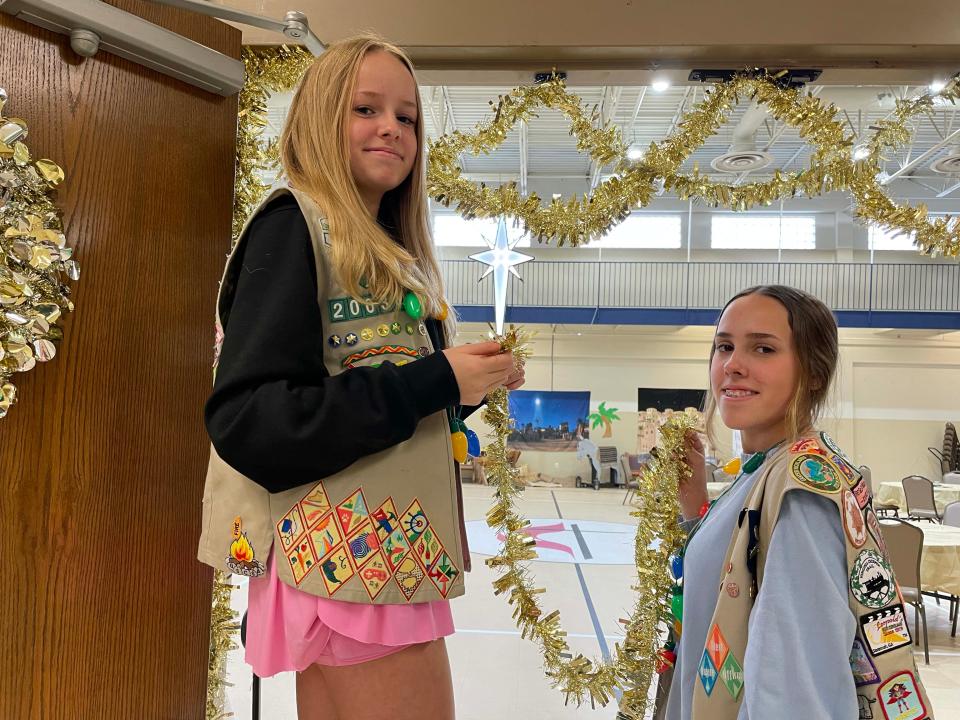 Girl Scouts Ana Berkheimer, 14, and Ava Berkheimer, 16, from Troop 20034 deck the halls with golden tinsel, making for a festive atmosphere at the annual community Christmas Party Dec. 17, 2023, at Beaver Ridge United Methodist Church.