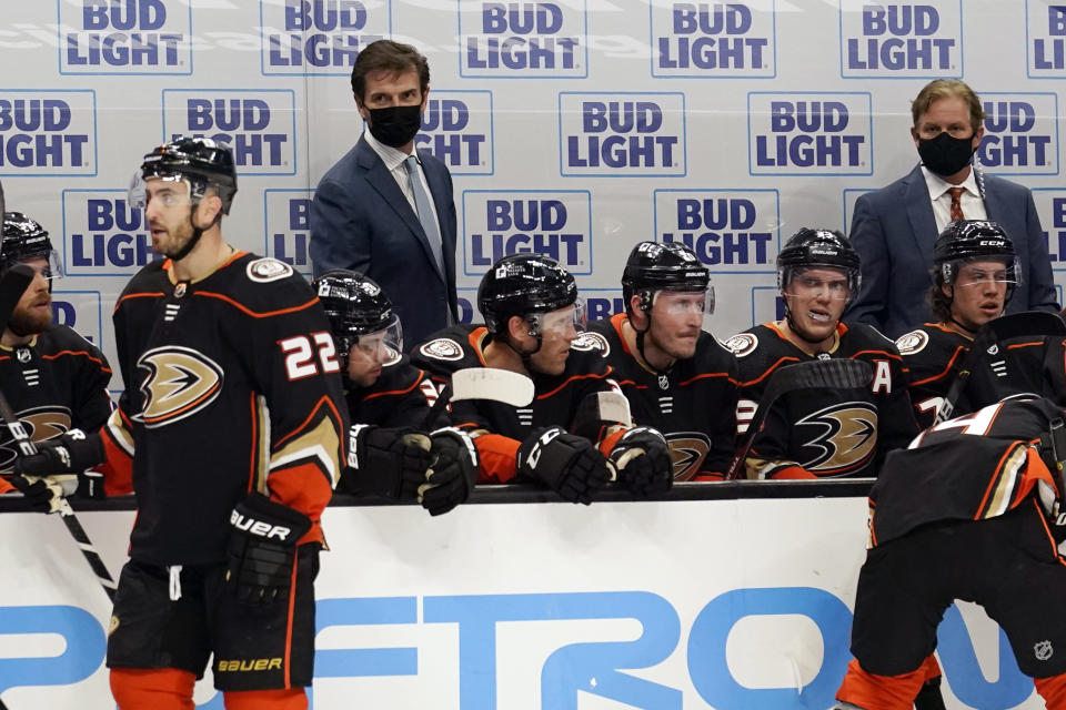 Anaheim Ducks head coach Dallas Eakins, top left, watches from the bench during the first period of an NHL hockey game against the Minnesota Wild, Monday, Jan. 18, 2021, in Anaheim, Calif. (AP Photo/Marcio Jose Sanchez)