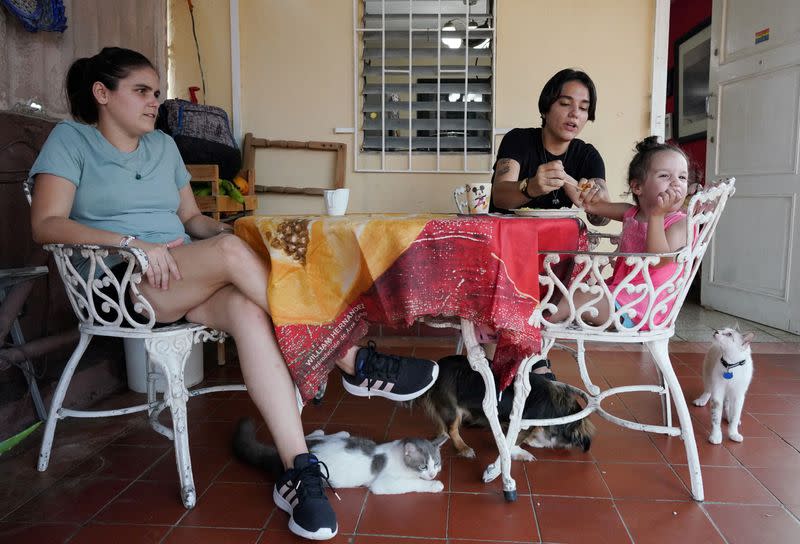 Couple Gabriela Alfonso Perez and Ria Acosta sits in their garden in Havana