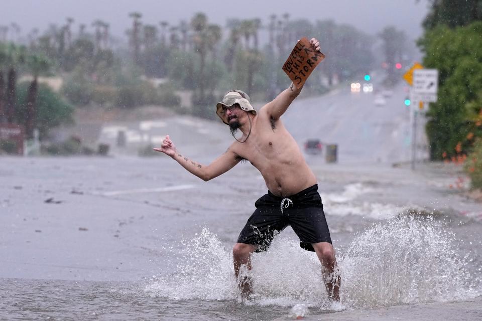 Joseph Wolensky stands in the street with a sign that says "You call this a storm?" Sunday, Aug. 20, 2023, in Palm Desert, Calif. Forecasters said Tropical Storm Hilary was the first tropical storm to hit Southern California in 84 years, bringing the potential for flash floods, mudslides, isolated tornadoes, high winds and power outages. (AP Photo/Mark J. Terrill)