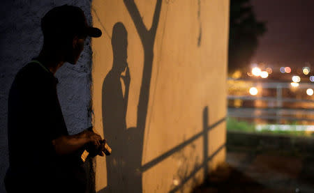 A Brazilian drug gang member poses with a gun in a slum in Rio de Janeiro, Brazil March 17, 2018. Picture taken March 17, 2018. REUTERS/Alan Lima