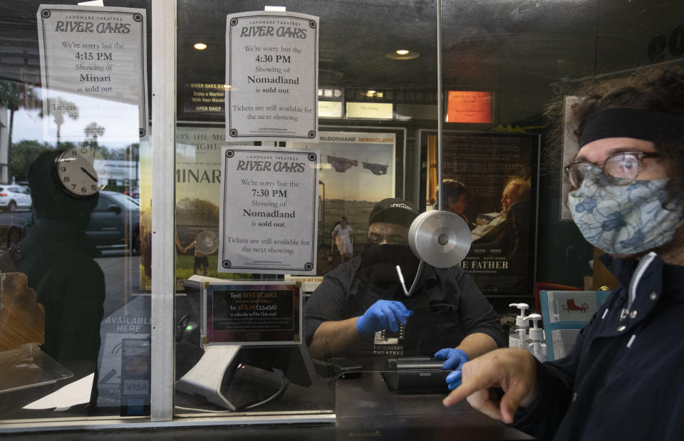 River Oaks Theatre staff Ricky Ruiz helping guests buying tickets as screenings are selling out at the box office on the second last day of the theater Wednesday, March 24, 2021, in Houston. The historic theater that director Richard Linklater called his “film school” and that for decades was the place to catch hard-to-find independent and foreign films has closed for good. Like many U.S. movie theaters and other businesses, the River Oaks Theatre was a victim of the coronavirus pandemic.(Yi-Chin Lee/Houston Chronicle via AP)