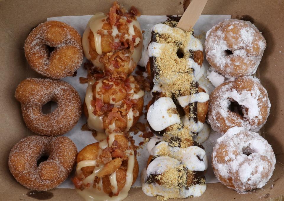 Twelve delicious and colorful min donut creations served at The Dainty Donut Factory food cart set up in the Shorewood Drive neighborhood Saturday morning, August 29, 2020 in Webster.  Pictured from left to right are Cinnamon & Sugar, Maple Bacon, S'mores, and Powdered Sugar. 
