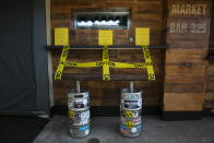 A bench made with kegs is taped off to prevent people from sitting at a bar temporarily closed due to the coronavirus pandemic Wednesday, July 8, 2020, in Los Angeles. (AP Photo/Jae C. Hong)