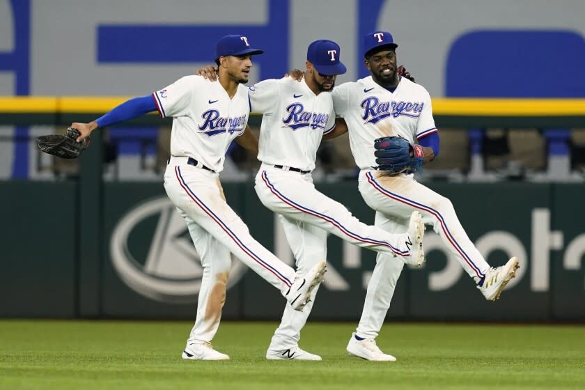 De izquierda a derecha, Bubba Thompson, el dominicano Leody Taveras y el cubano Adolis García, festejan un triunfo de los Rangers de Texas sore los Atléticos de Oakland, el jueves 18 de agosto de 2022 (AP Foto/Tony Gutiérrez)