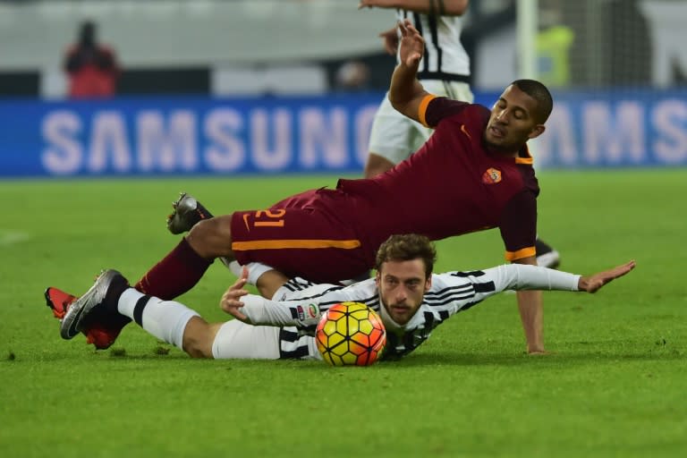 Roma's midfielder William Vainqueur (top) fights for the ball with Juventus' midfielder Claudio Marchisio during the Italian Serie A football match at "Juventus Stadium" in Turin on January 24, 2016