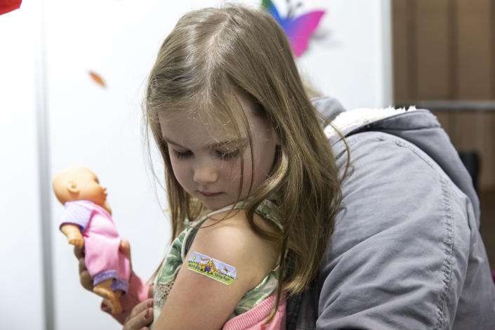 A child looks at her band aid after receiving the vaccination against the COVID-19 virus in Tulln, a city close from Vienna, Austria, Wednesday, Dec. 1, 2021. Austria’s lockdown has officially been extended until Dec. 11 as planned amid signs that the measures are helping to bring down a sky-high coronavirus infection rate. A parliamentary committee signed off Tuesday on the extension of the country’s fourth national lockdown of the pandemic that started on Nov. 22. (AP Photo/Lisa Leutner)
