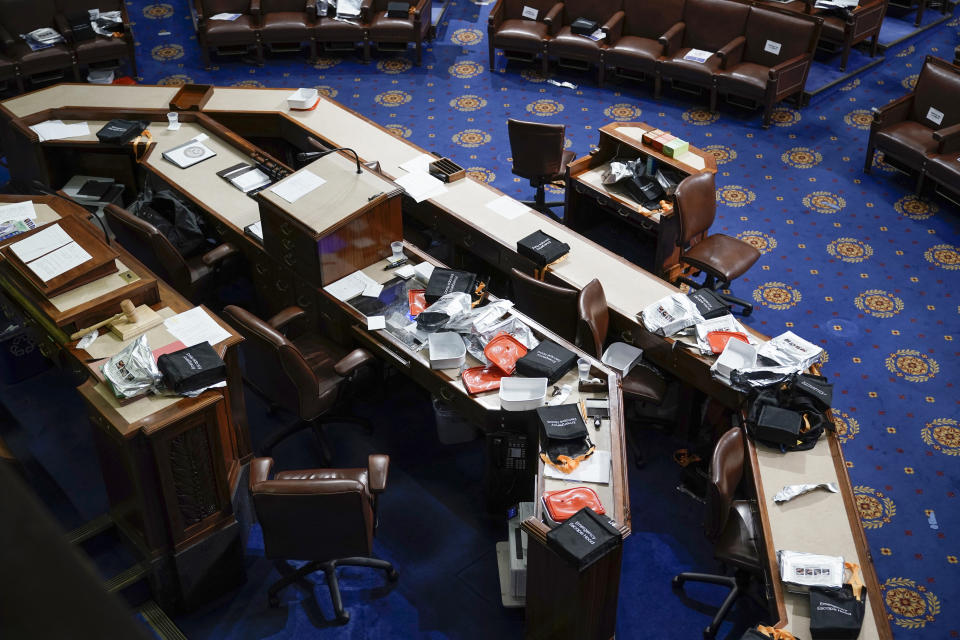 Papers and gas masks are left behind after House of Representatives members left the floor of the House chamber as protesters try to break into the chamber at the U.S. Capitol on Jan. 6, 2021, in Washington. (AP Photo/J. Scott Applewhite, File)