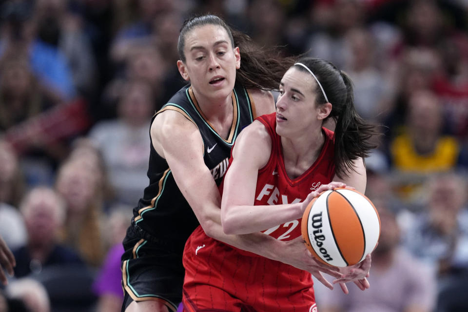 Indiana Fever's Caitlin Clark (22) makes a pass as New York Liberty's Breanna Stewart (30) defends during the first half of a WNBA basketball game, Saturday, July 6, 2024, in Indianapolis. (AP Photo/Darron Cummings)