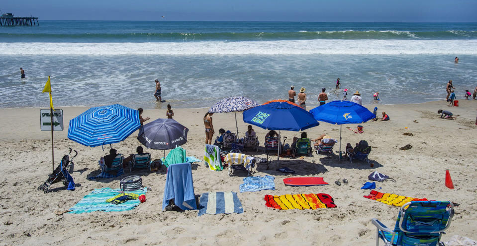 With most of Southern California's coastline is shut down for the Fourth of July holiday due to a spike in coronavirus cases, the beach in San Clemente, Calif., remains open as crowds, socially distanced, fill the sand Saturday, July 4, 2020. (Mark Rightmire/The Orange County Register via AP)