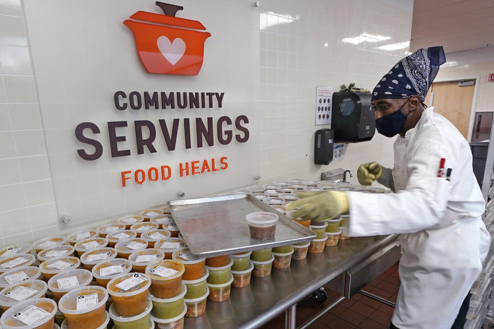 Chef Jermaine Wall stacks containers of soups at Community Servings, which prepares and delivers scratch-made, medically tailored meals to individuals & families living with critical & chronic illnesses, Tuesday, Jan. 12, 2021, in the Jamaica Plain neighborhood of Boston. Food is a growing focus for insurers as they look to improve the health of the people they cover and cut costs. Insurers first started covering Community Servings meals about five years ago, and CEO David Waters says they now cover close to 40%. (AP Photo/Charles Krupa)