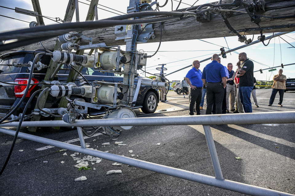 Maryland Gov. Wes Moore talks with Carroll County officials while touring the downed power lines and poles on Route 140, Tuesday, Aug. 8, 2023 in Westminster, Md. after powerful storms came through the area Monday evening. (Jerry Jackson/The Baltimore Sun via AP)