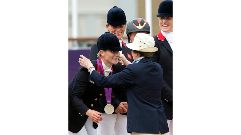 Zara smiles as she receives her silver medal from her mother Princess Anne