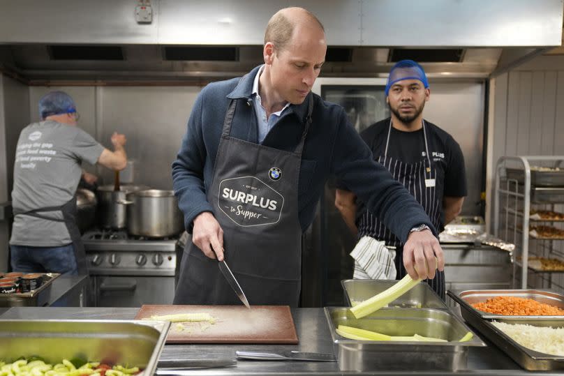 El príncipe William ayuda a preparar una salsa boloñesa durante una visita a Surplus to Supper, en Sunbury-on-Thames, Surrey, Inglaterra, el 18 de abril de 2024.