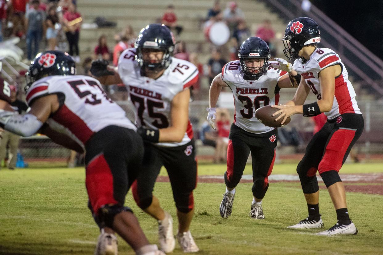 Franklin’s Brock Bradley hands off the ball to Addix Sutton, September 1, 2023 in the game at Swain County.