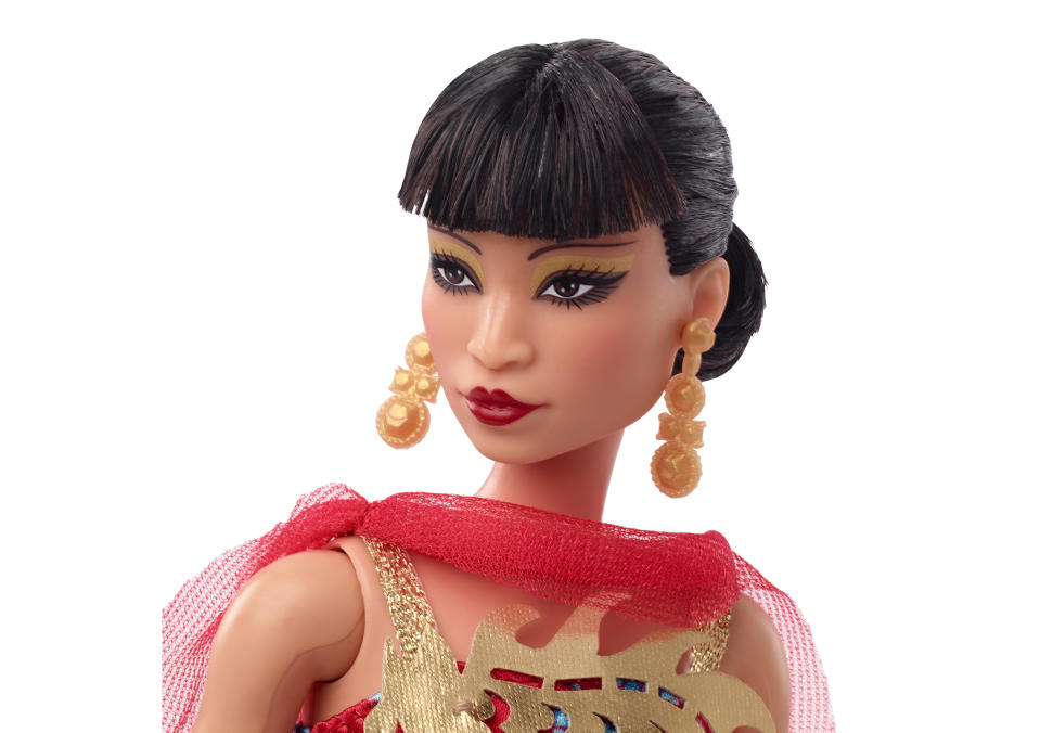 This image released by Mattel shows a Barbie doll in the image of Asian American Hollywood trailblazer Anna May Wong, part of their Inspiring Women Series. The doll is dressed in a frock inspired by Wong's appearance in the 1934 movie “Limehouse Blues,” a red gown with a shiny golden dragon design and cape. (Jason Tidwell/Mattel via AP)